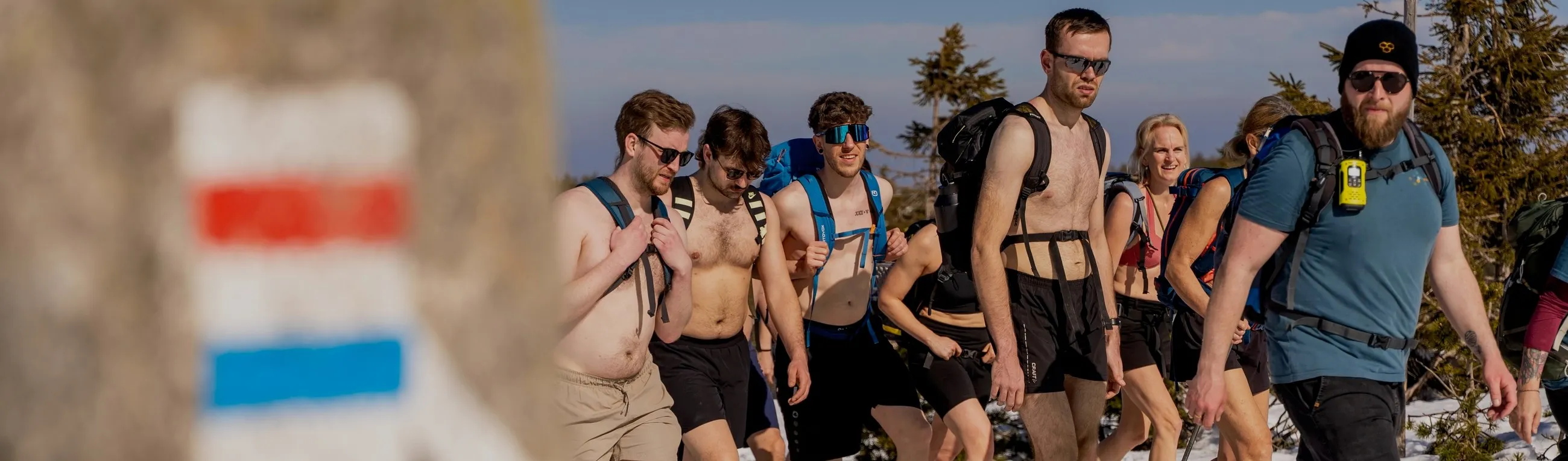 Gruppe wandert leicht bekleidet über einen verschneiten Bergrücken im Riesengebirge