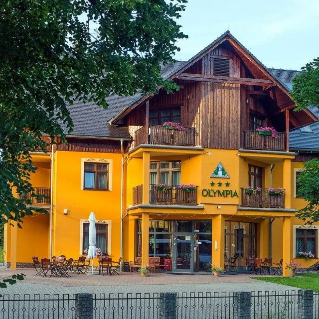 Hotel Olympia in Przesieka, gelbes Haus mit Holzgiebel und Balkonen